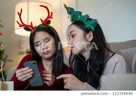 Focused Lesbian Partners Reviewing Holiday Shopping List Precision in Festive Finance 123356640