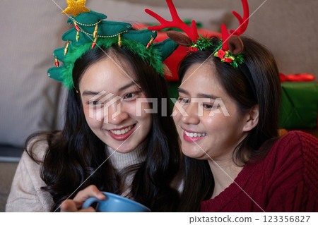 Interracial Friends Savoring Hot Drinks Amidst Festive Decor 123356827
