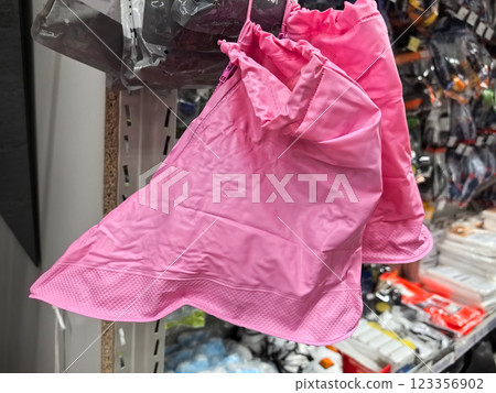 Bright pink raincoats hanging in a vibrant store display 123356902