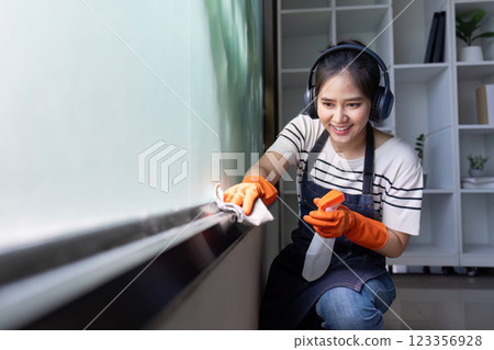Joyful Cleaner Enjoying Work Vibrant Home Cleaning Concept with Duster and Music 123356928