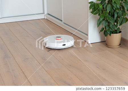 Robot vacuum cleaner vacuuming dust at room. Natural sunny lights 123357659
