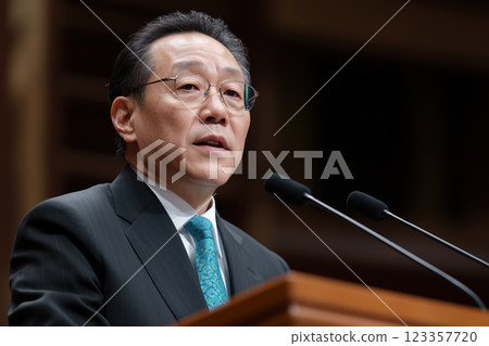 Portrait of a mature asian politician speaking from tribune 123357720