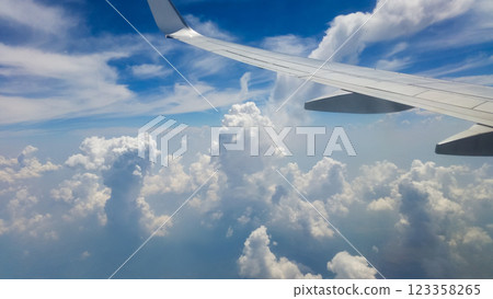 beautiful thick clouds in the sky from the height of the flight of the plane with a view of the wing with engines 123358265