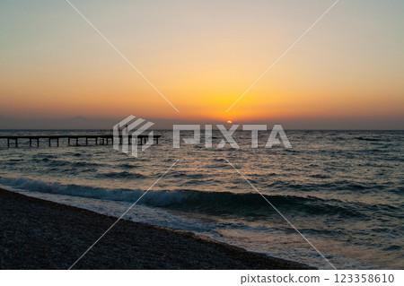 silhouette of people walking along the sea beach pier at sunset silhouette of people walking along the sea beach pier at sunset 123358610