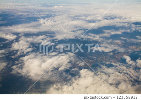 beautiful thick clouds in the sky from the height of the flight of the plane with a view of the continent and countries 123358912