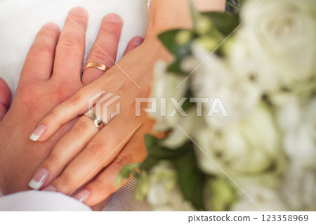 close-up of a couple in love holding hands with wedding rings close-up of a couple in love holding hands with wedding rings 123358969