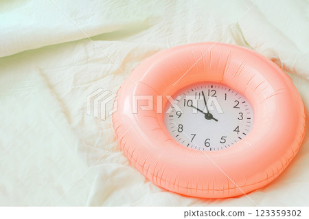 inflatable swimming circle with alarm clock on a light background 123359302