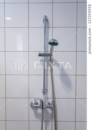 A Beautiful Modern Shower Fixture Perfectly Positioned in a Minimalist Bathroom Setting A Beautiful Modern Shower Fixture Perfectly Positioned in a Minimalist Bathroom Setting 123359458