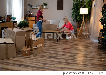 Unpacking and thoughtfully organizing a brand new home alongside friends can be a joyful experience 123359474