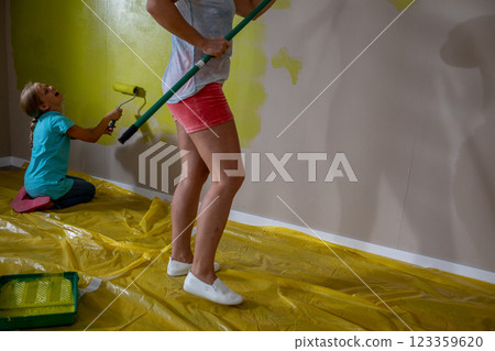 Children joyfully painting a wall with vibrant colors, showcasing their creativity and playfulness 123359620