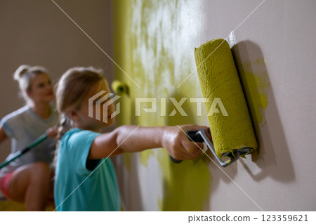 Children joyfully painting a room yellow together, creating a colorful atmosphere 123359621