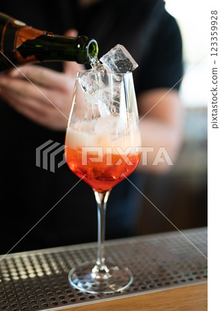 the bartender prepares a beautiful alcoholic cocktail at the bar counter 123359928