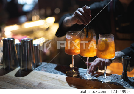 the bartender prepares a beautiful alcoholic cocktail at the bar counter 123359994