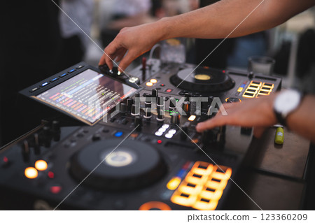 a DJ plays music on a controller at a party 123360209