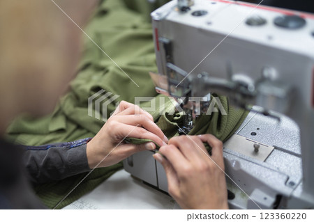 workers in an industrial garment factory sew clothes on sewing machine workers in an industrial garment factory sew clothes on sewing machine 123360220