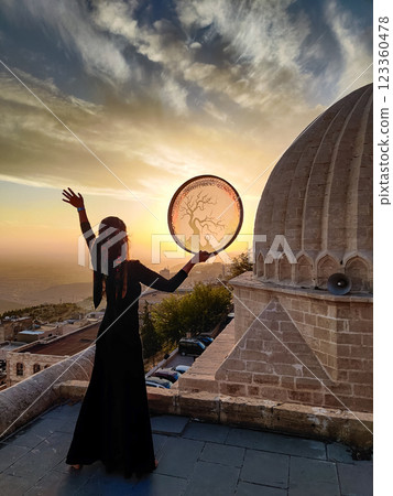 silhouette of a girl with a shamanic drum near Sultan Isa Medrese Mosque in Turkey 123360478