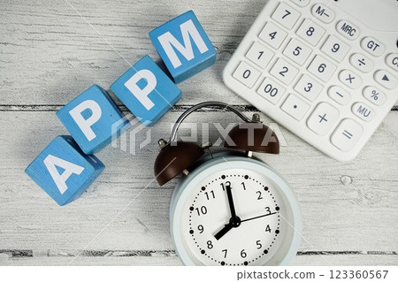 APPM (Average Price Per Minute) text with alarm clock and calculator on wooden background 123360567