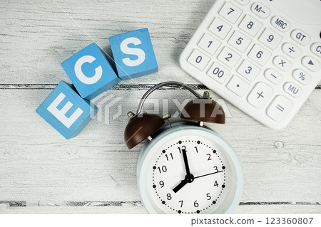 ECS (Electronic Clearing Service) text with alarm clock and calculator on wooden background ECS (Electronic Clearing Service) text with alarm clock and calculator on wooden background 123360807
