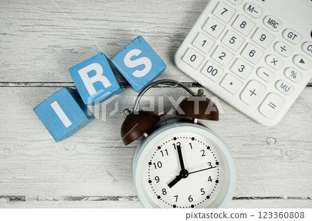IRS (Interest Rate Swap) text with alarm clock and calculator on wooden background IRS (Interest Rate Swap) text with alarm clock and calculator on wooden background 123360808