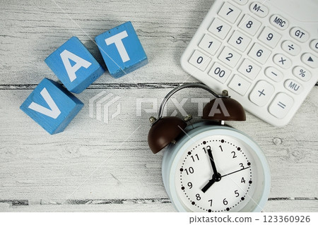 VAT (Value Added Tax) text with alarm clock and calculator on wooden background VAT (Value Added Tax) text with alarm clock and calculator on wooden background 123360926