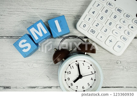 SMI (Service Measurement Index) text with alarm clock and calculator on wooden background SMI (Service Measurement Index) text with alarm clock and calculator on wooden background 123360930