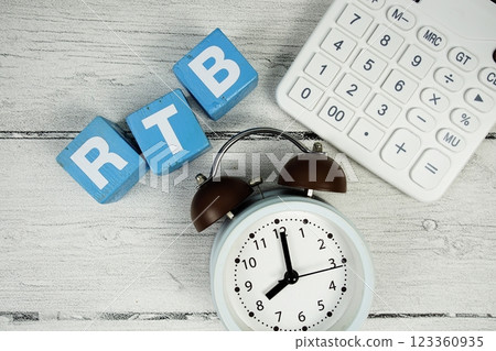 RTB (Real Time Bidding) text with alarm clock and calculator on wooden background 123360935