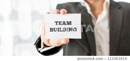 Businessman Showing Card with Team Building Texts Businessman Showing Card with Team Building Texts 123361614