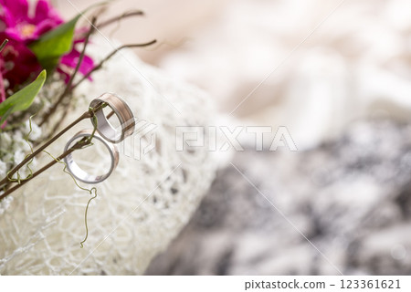 Close Up of Two Wedding Rings Hanging on Twigs of Bridal Bouquet with Fuchsia Colored Flowers Close Up of Two Wedding Rings Hanging on Twigs of Bridal Bouquet with Fuchsia Colored Flowers 123361621