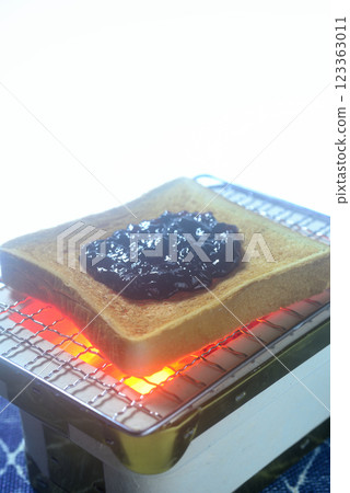 Toasting bread on a charcoal grill Toasting bread on a charcoal grill 123363011