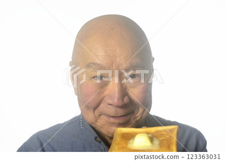 一位老人微笑著吃著烤麵包 一位老人微笑著吃著烤麵包 123363031