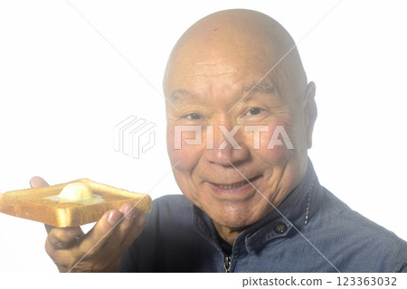 An elderly man eating toasted bread with a smile An elderly man eating toasted bread with a smile 123363032