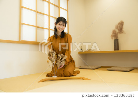 A woman sitting upright in a Japanese-style room 123363185