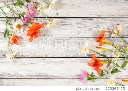 Flowers of lilies, daisies and hollyhocks on an old wooden background, summer and autumn banner for product advertising, abstract floral arrangement, rustic style, holiday card, selective focus. Flowers of lilies, daisies and hollyhocks on an old wooden background, summer and autumn banner for product advertising, abstract floral arrangement, rustic style, holiday card, selective focus. 123363415