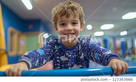 young boy cerebral palsy practices walking parallel bars in modern rehabilitation center guided supportive therapist. environment is bright and encouraging. 123363666