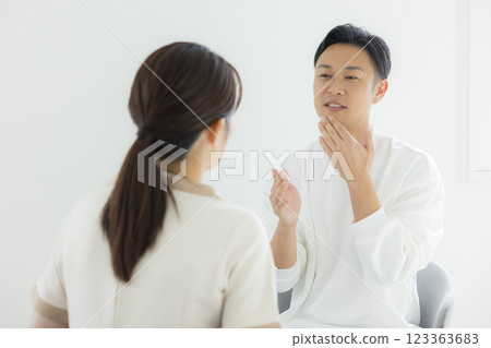 一名男子正在接受女美容師的諮詢 一名男子正在接受女美容師的諮詢 123363683