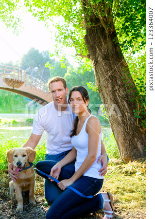 couple happy posing with golden retirever dog 123364007