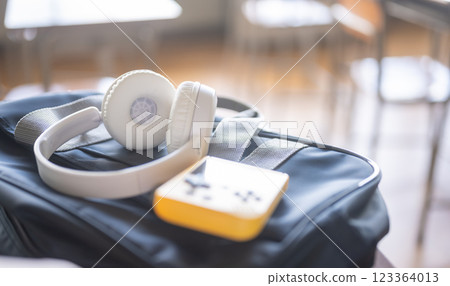 Headphones and a game console on a school desk 123364013