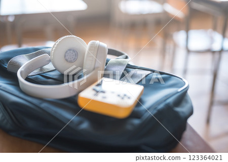 Headphones and game console on a school desk Headphones and game console on a school desk 123364021