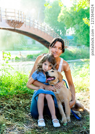 daughter and mother with golden retriever 123364024