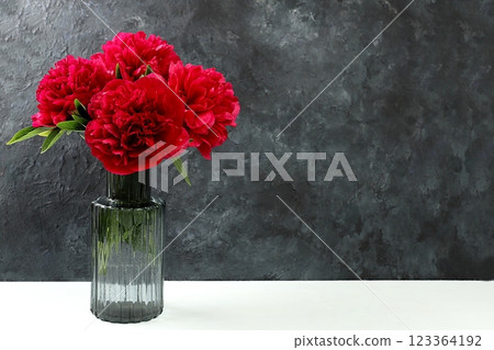 Beautiful peonies flowers in a vase on dark grunge background with place for text, summer banner for advertising, minimal holiday concept with flowers, greeting card for wedding, birthday, mother's 123364192