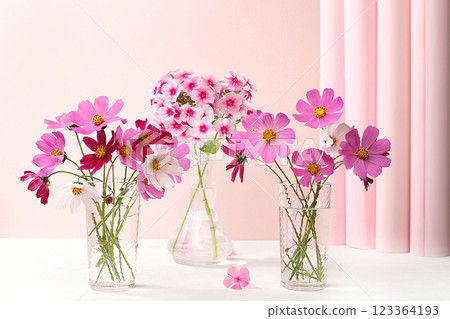 Beautiful chamomile flowers and phloxes in a vase on a light background, abstract flower arrangement, Home interior with decor elements, still life with place for text, floral card for birthday, 123364193