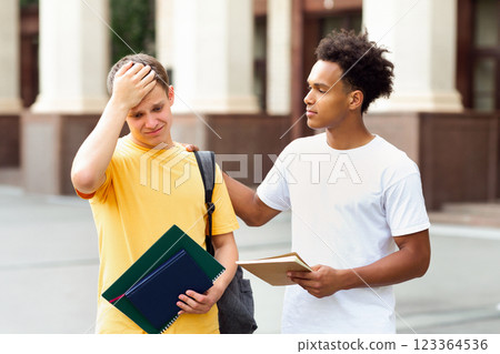 Failed test. Teenage guy consoling friend over bad exam result outdoors 123364536