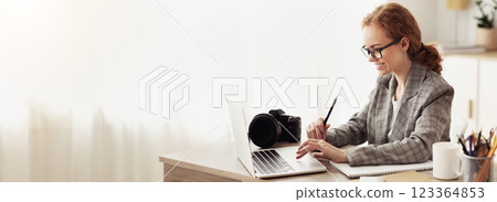 Young reporter transfering image data from camera to laptop, ready to write new article Young reporter transfering image data from camera to laptop, ready to write new article 123364853