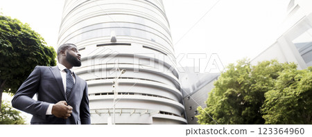 Pensive young african american executive staying outdoors near modern business center, low-angle shot with free place 123364960