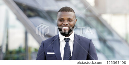 Portrait Of Successful Black Business Man Smiling And Looking At Camera Against Modern Office Building. Free Space, Shallow Depth. 123365408