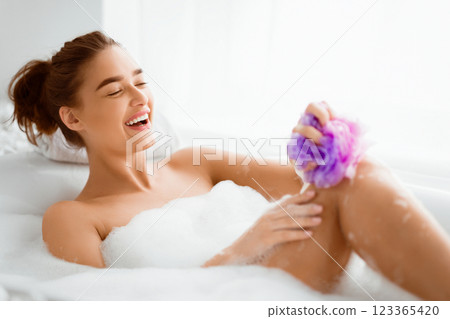 Woman Washing Leg With Sponge In Bath With Foam, Relaxing In Bathtub 123365420