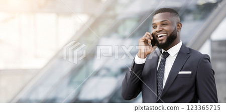 Business Communication. Cheerful Afro Businessman Having Phone Conversation In City Center. Copy Space Business Communication. Cheerful Afro Businessman Having Phone Conversation In City Center. Copy Space 123365715