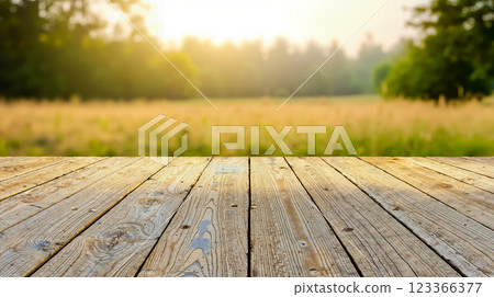 A wooden table in front of a field of grass and trees 123366377