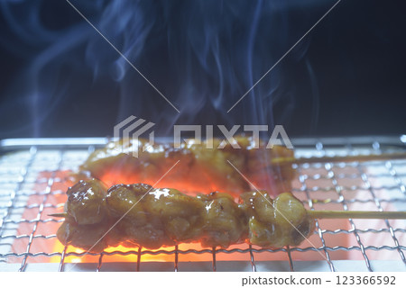 Grilling yakitori on a charcoal grill with rising smoke Grilling yakitori on a charcoal grill with rising smoke 123366592