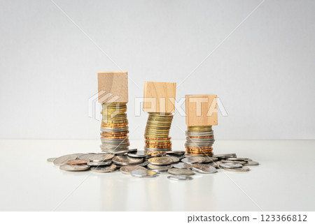 Three toy blocks on top of coins. 123366812